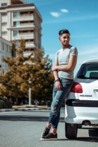 man in gray crew neck t-shirt and blue denim jeans standing on road during daytime