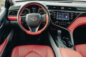 Explore the luxurious design features of a Toyota Camry with a bold red leather interior, showcasing its stylish dashboard.