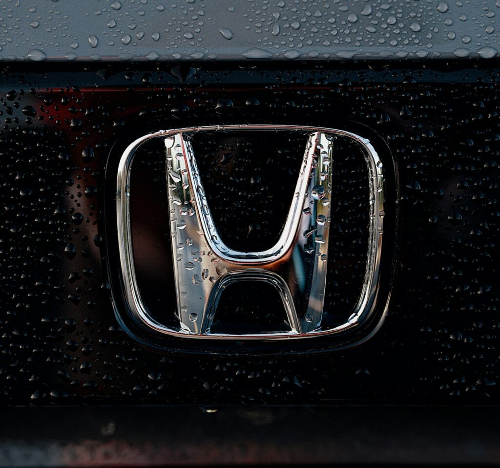 The shiny honda emblem is wet from rain.
