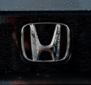 The shiny honda emblem is wet from rain.