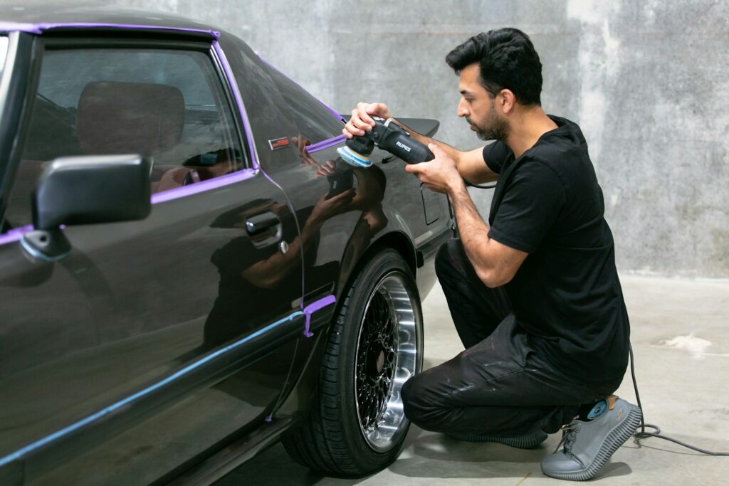 Man polishing a classic car's paintwork.