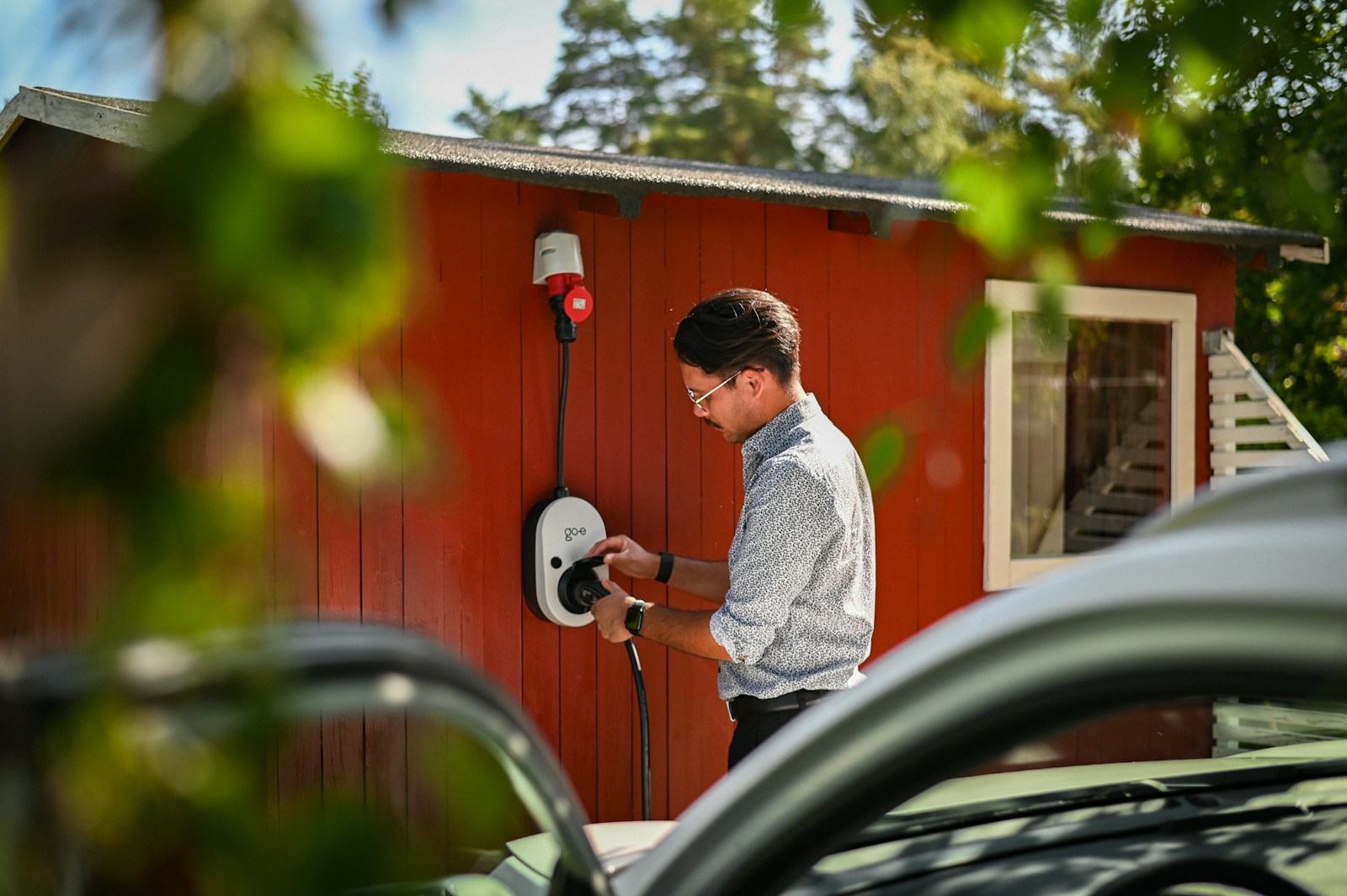 Man plugging in an electric car charger.